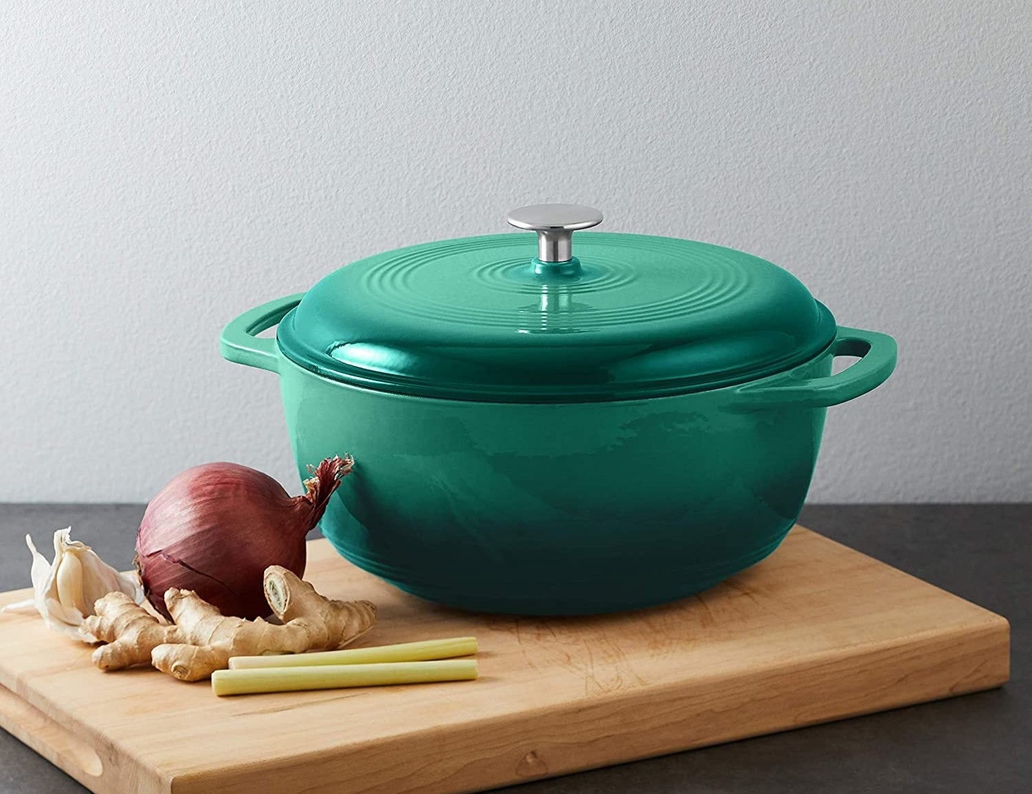 an enamelled cast iron dutch oven on a wooden cutting board