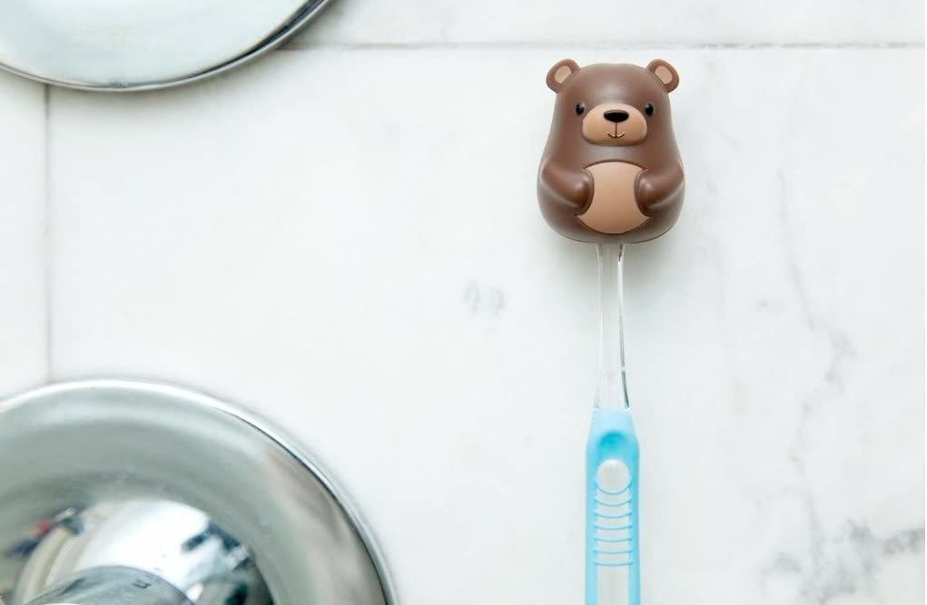 The bear-shaped toothbrush holder with a toothbrush inside