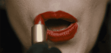 A person applying red lipstick