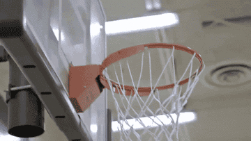 A basketball falling into a net