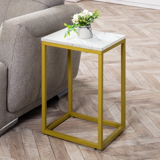 square-top side table with a faux marble top and gold legs and base