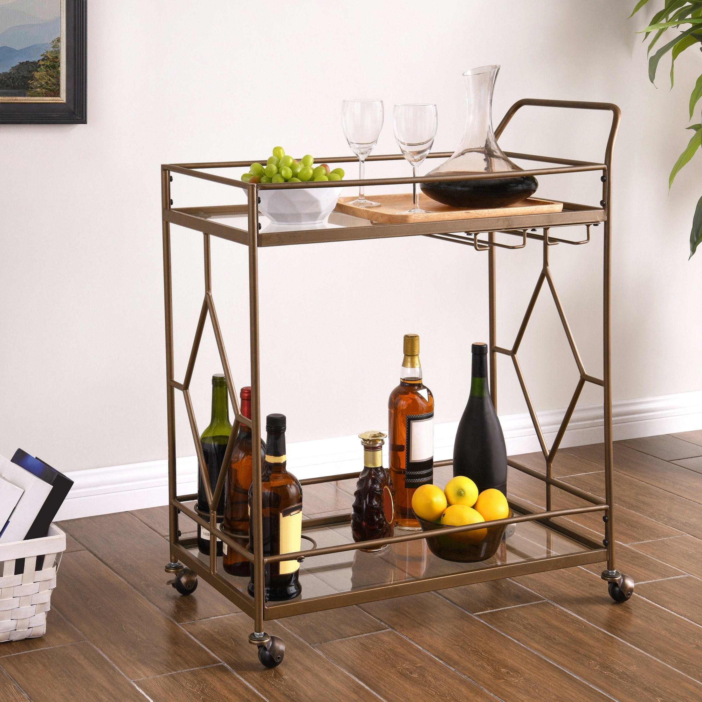 two-tiered gold-ish bronze rolling bar cart with a push handle and a diamond pattern on each side