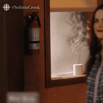 Gif of Stevie from &quot;Schitts Creek&quot; asking &quot;what&#x27;s up?&quot; and wearing a lot of makeup