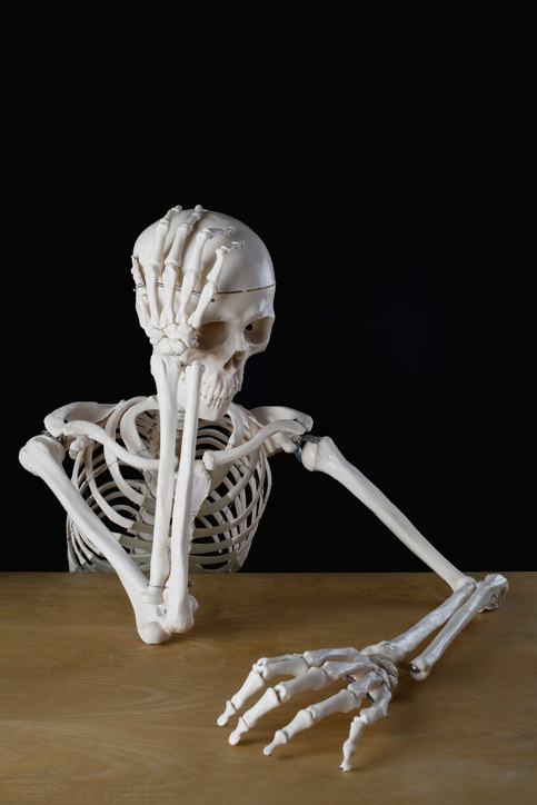 a skeleton at a desk