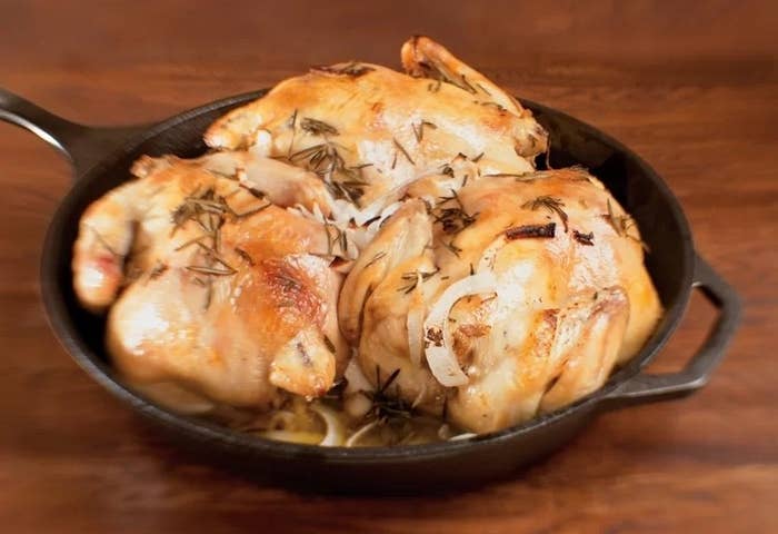a black cast iron skillet with chicken in it