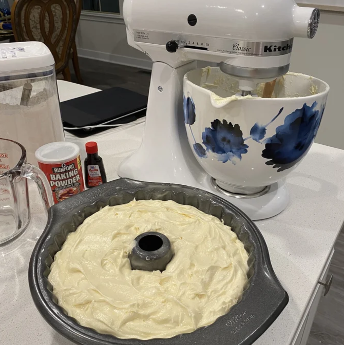 a white mixer with a cake in front of it