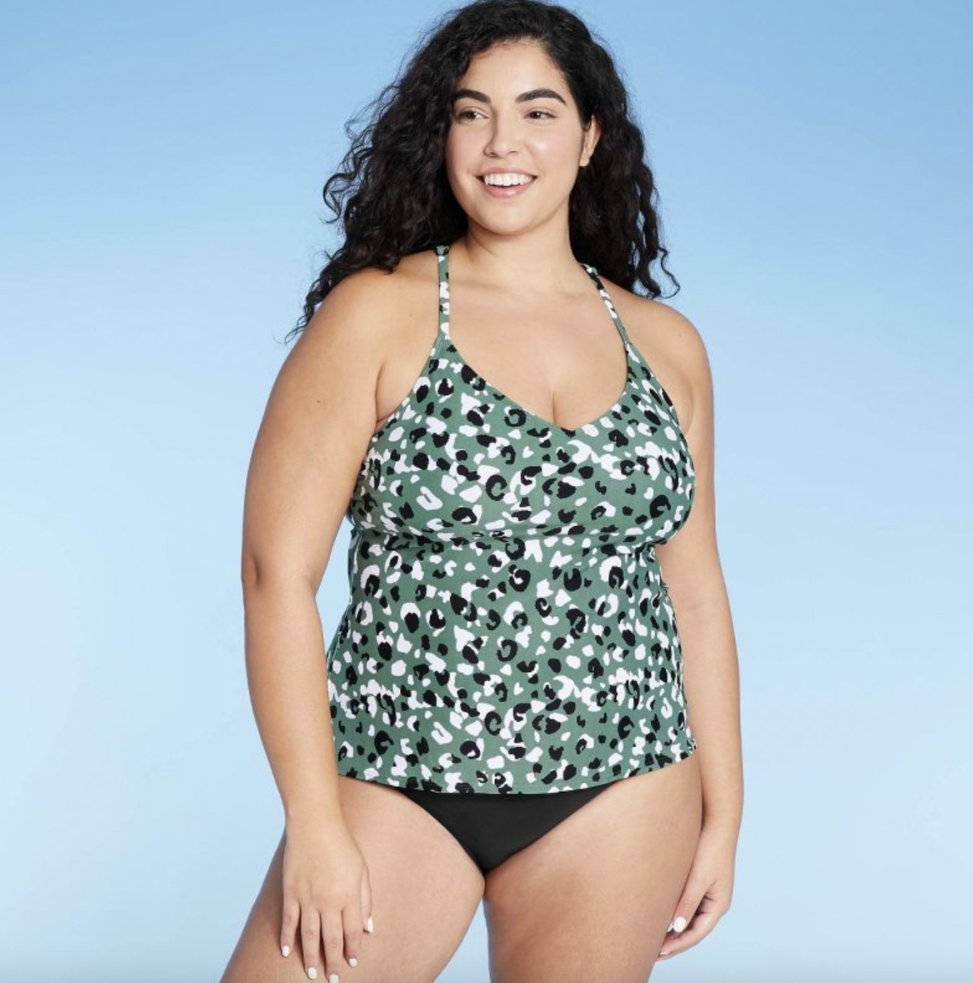 A person wearing a green animal print T-back tankini top
