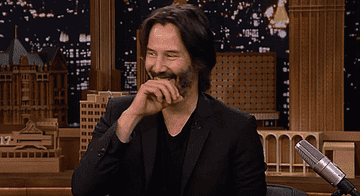 keanu covering his mouth as he laughs