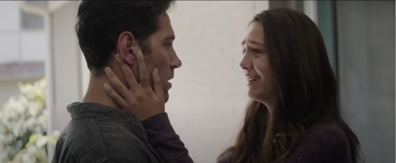 Cassie holding her dad&#x27;s face, looking overjoyed as they are reunited