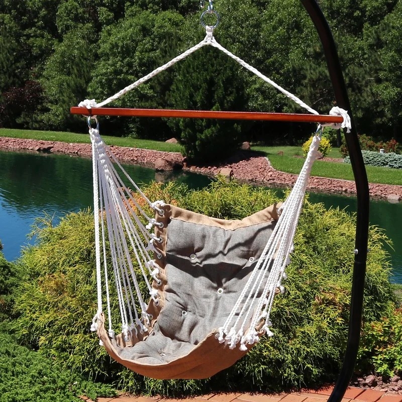 A brown and gray porch swing with a hammock net