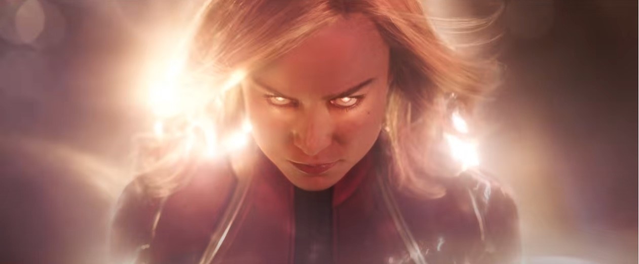 Captain Marvel looking angry, her blonde hair and eyes glowing gold