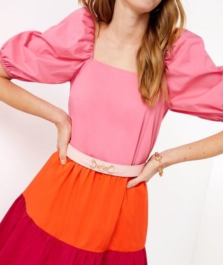 A model in a dress with the pink belt on