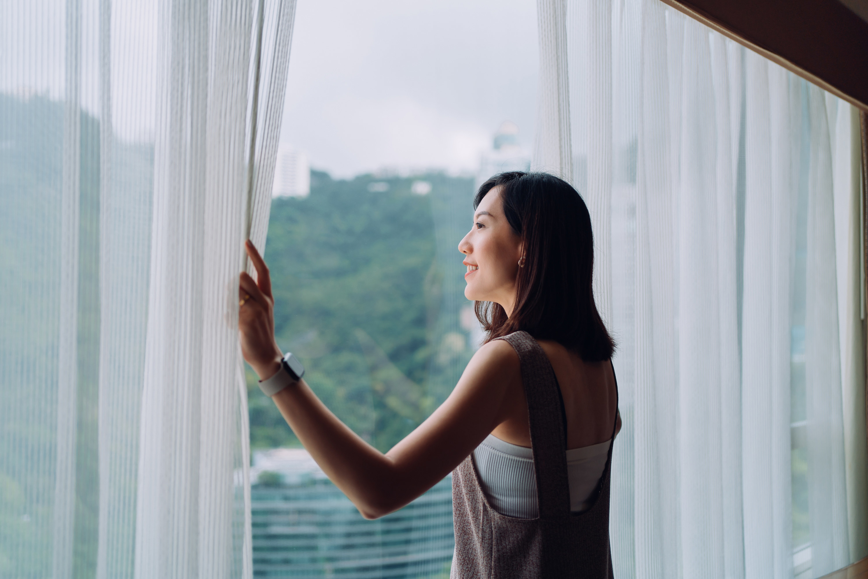 An Asian woman looking at a window