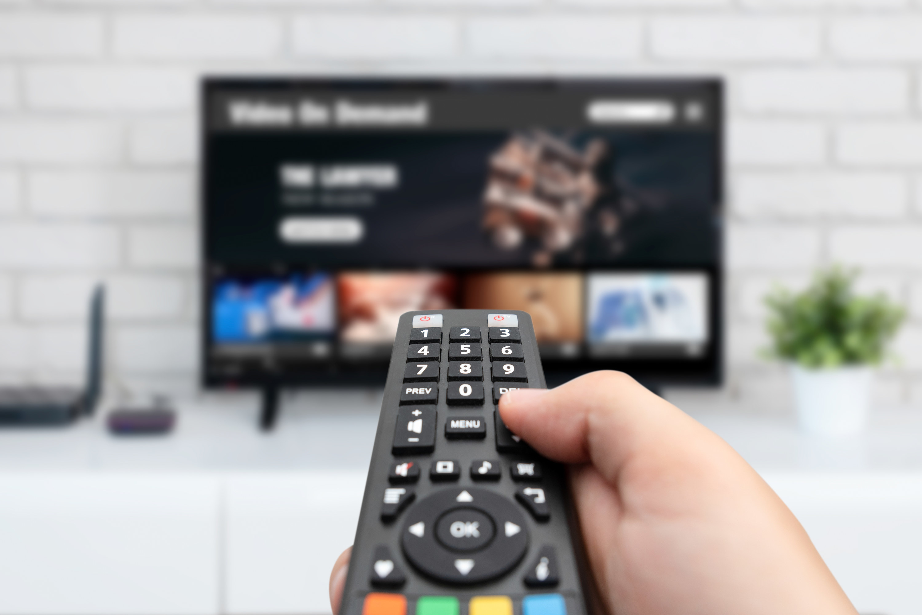 Man watching TV, remote controller in hand