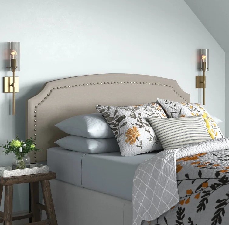 An image of a grey upholstered panel headboard