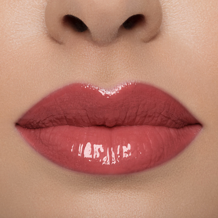 A close up shot of a model's lip with lip gloss on
