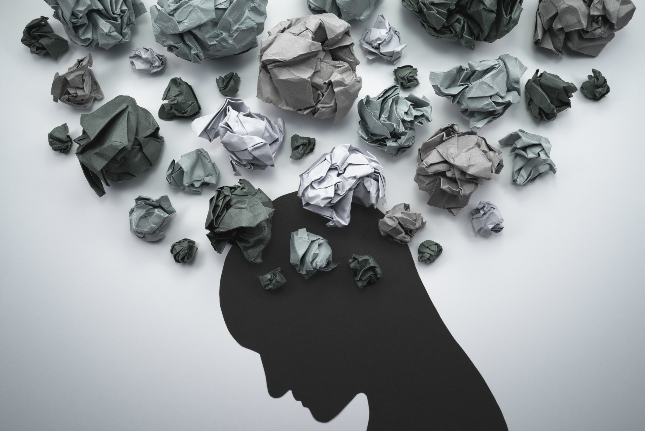 A drawing of a human head with balls of paper surrounding it