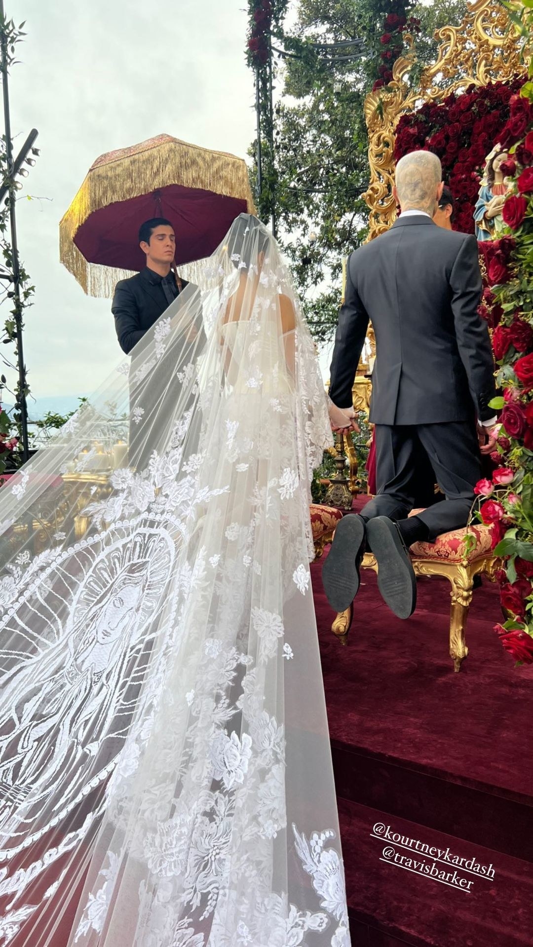 Kourtney and Travis kneeling on the two footstools in front of the alter