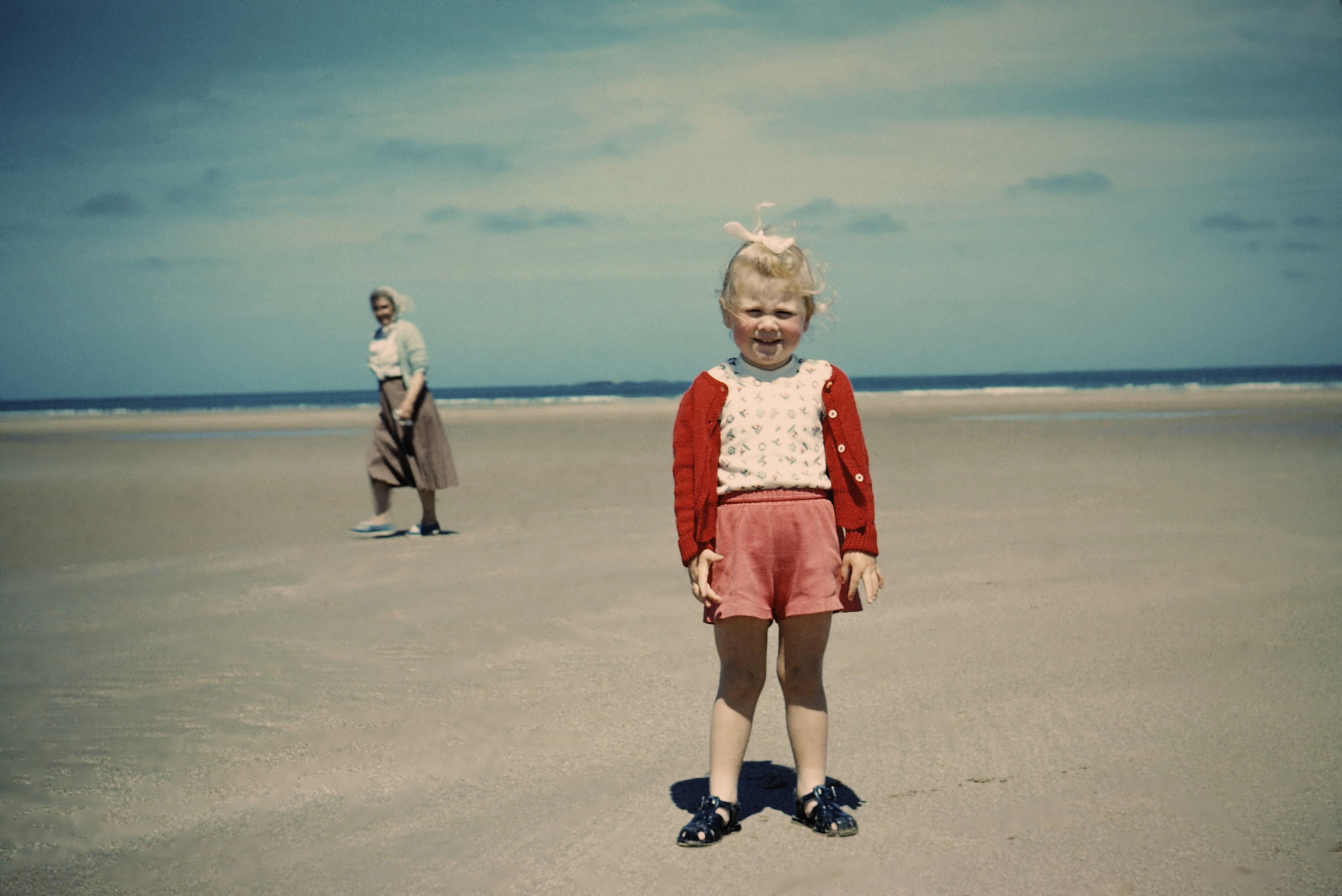 A young girl stands on the beach