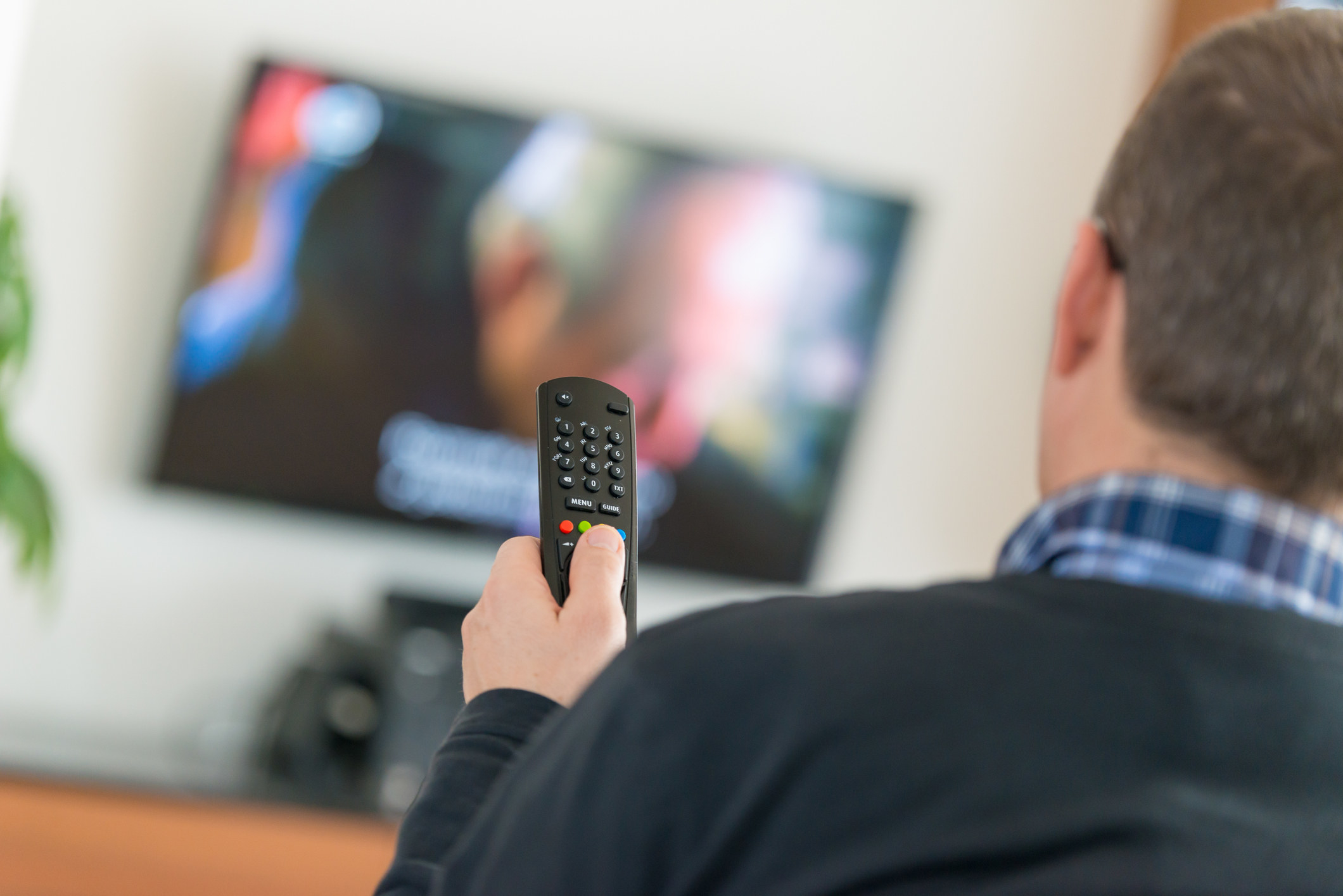 A man using a television remote control