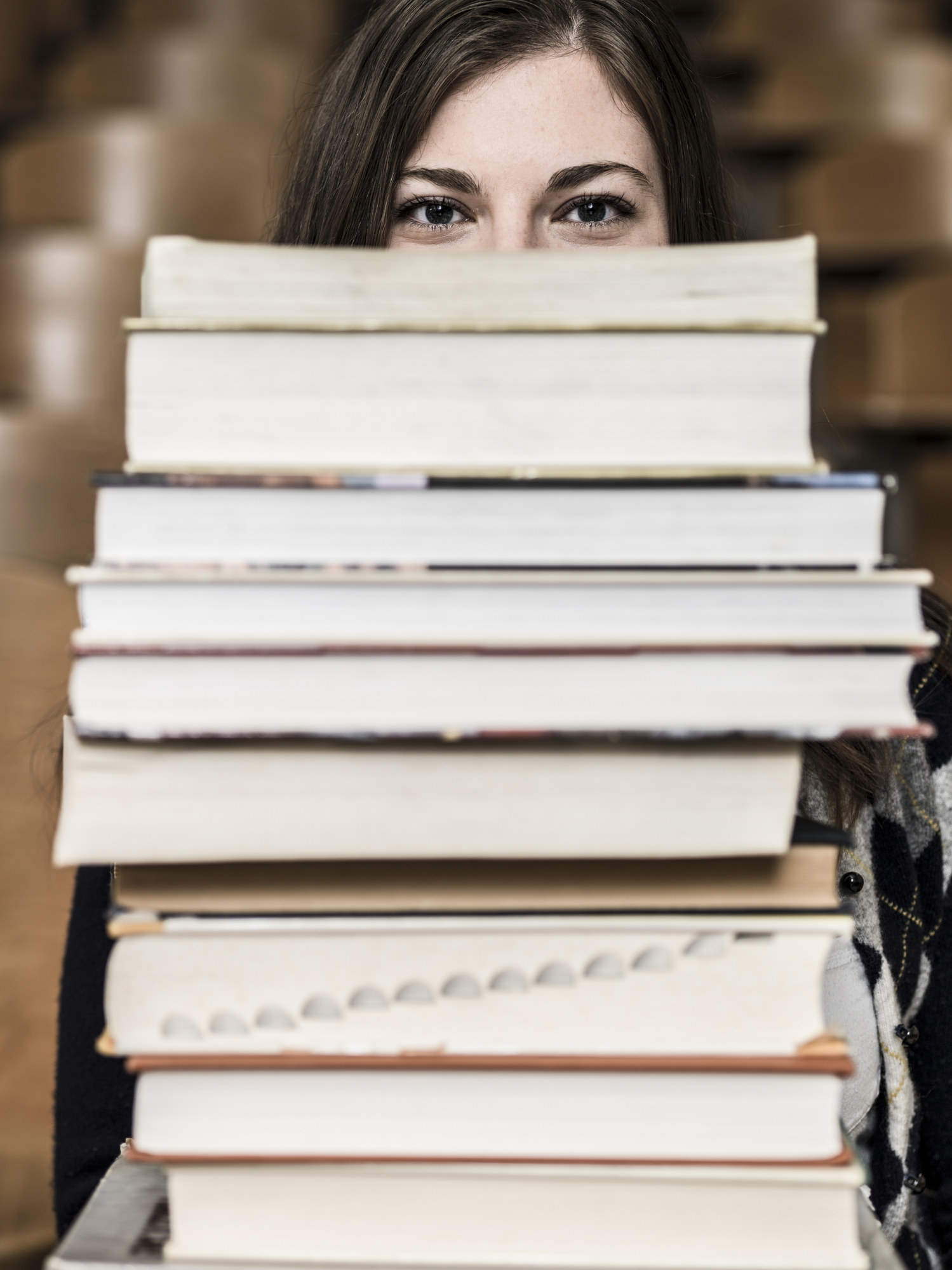 A woman with a stack of books in front of her