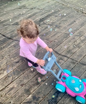 reviewer's child pushing the bubble lawn mower