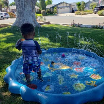 reviewer's photo of their child playing in the splash pad