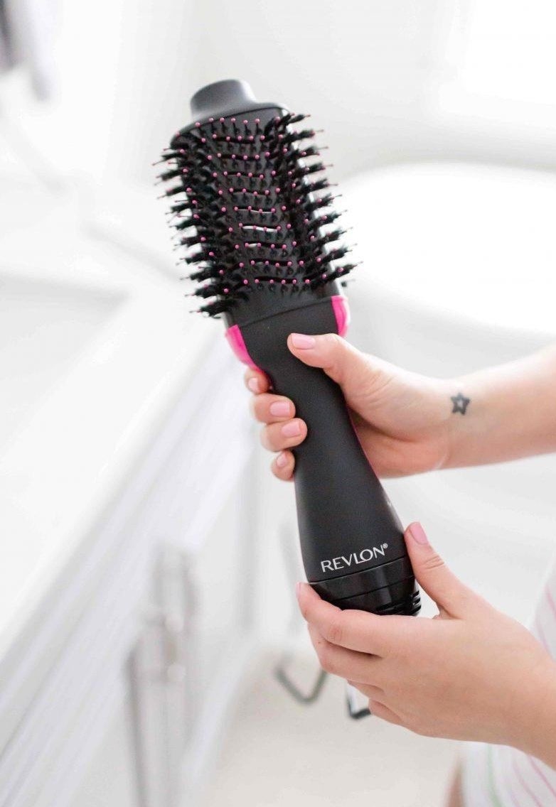 a reviewer holds the hairdryer