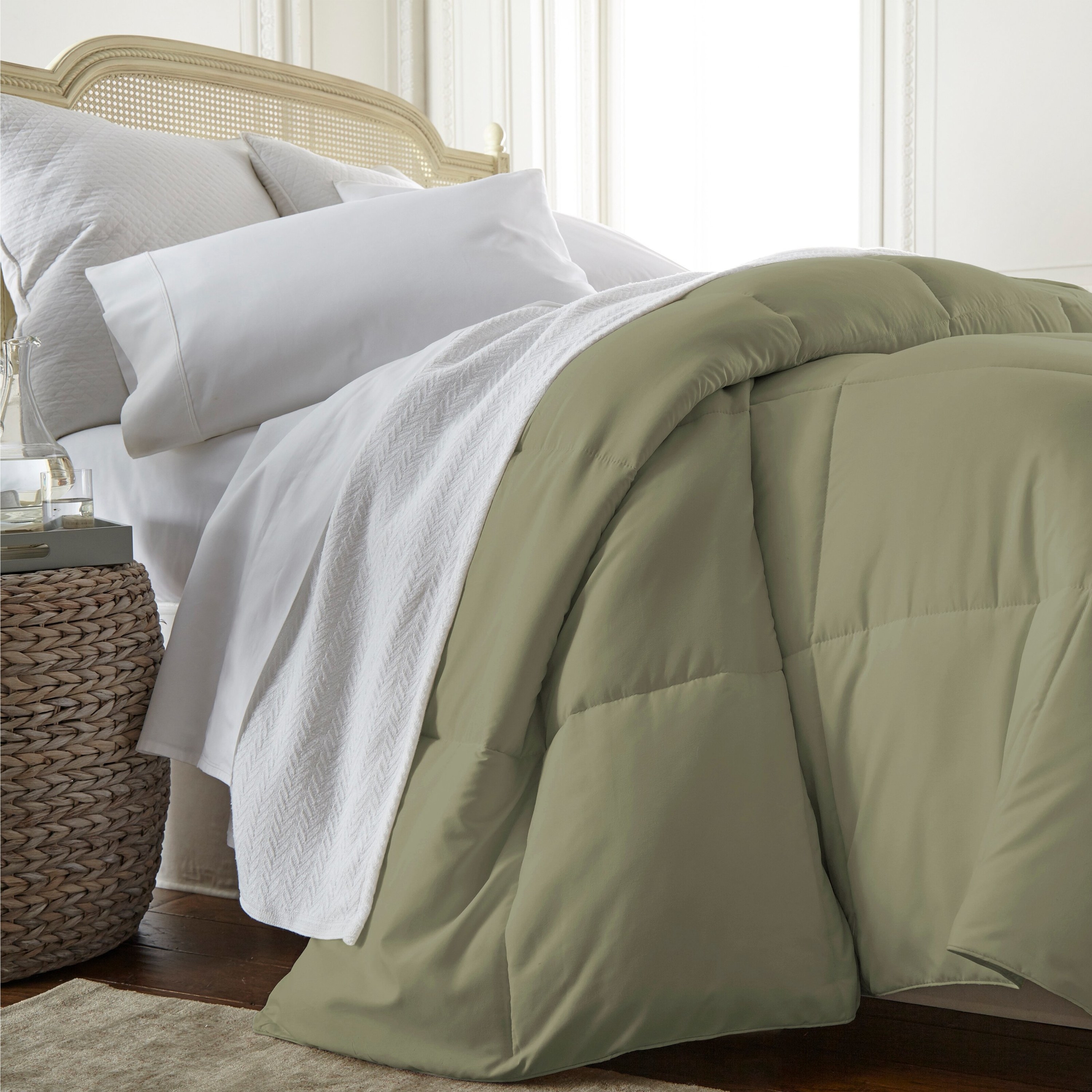 A green microfiber down comforter draped over a bed
