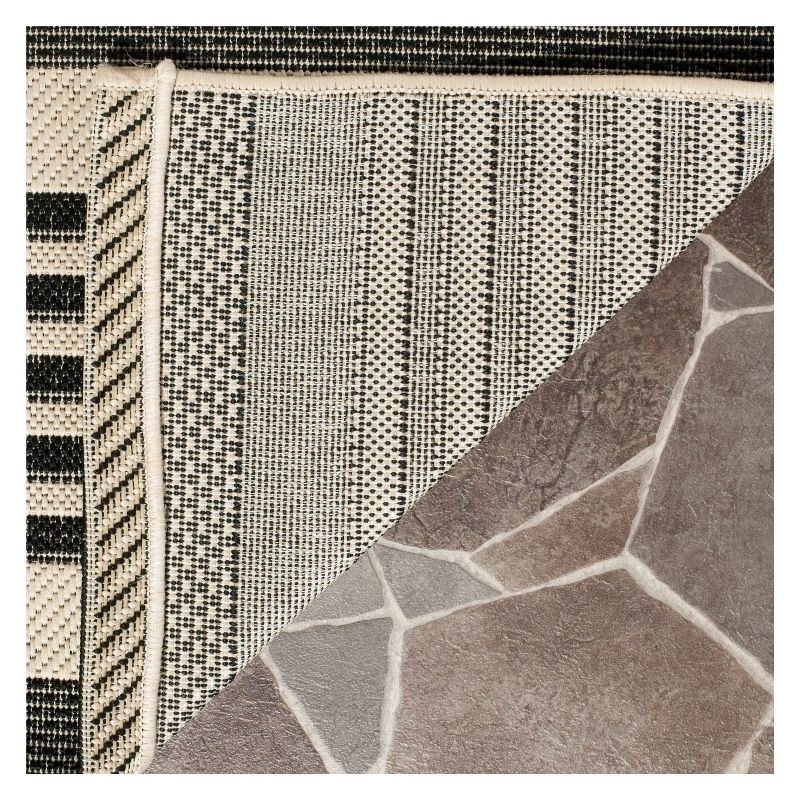 The black striped rug folded up over cracked tile floor