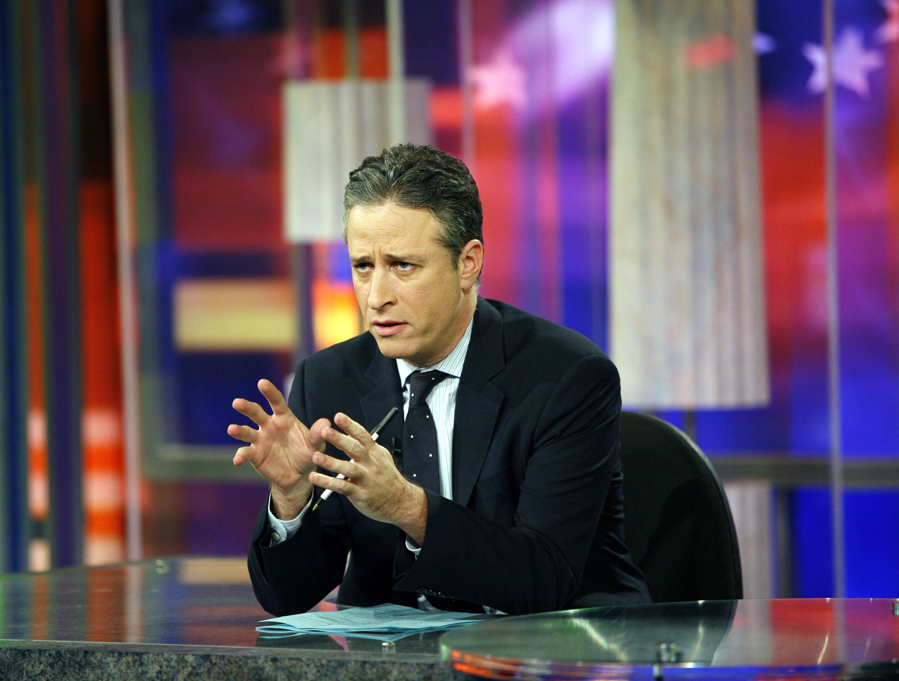 Jon Stewart behind the desk of the Daily Show