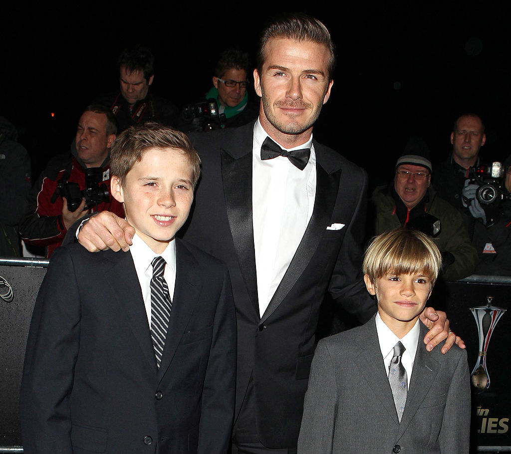 David, Brooklyn, and Romeo Beckham all wear dark suits