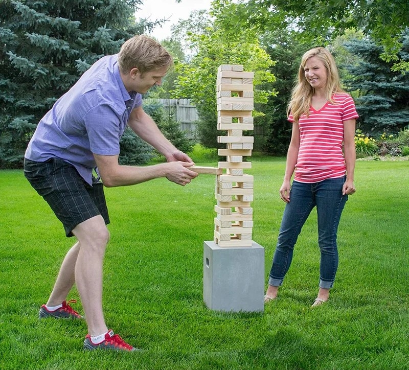 Two people playing the wooden block stacking game