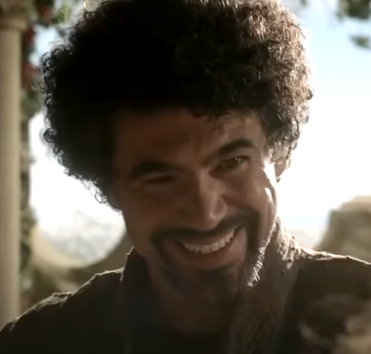 Miltos with a head full of curly hair and wide smile, unlike his character