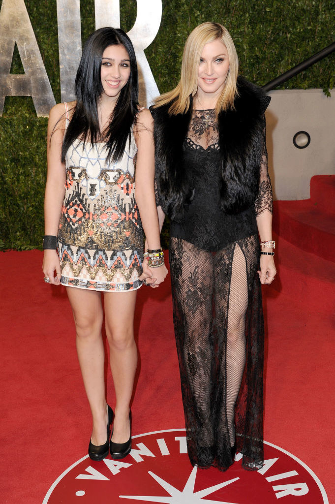 Lourdes Leon wears a patterned mini dress and Madonna wears a dark dress with a lace skirt