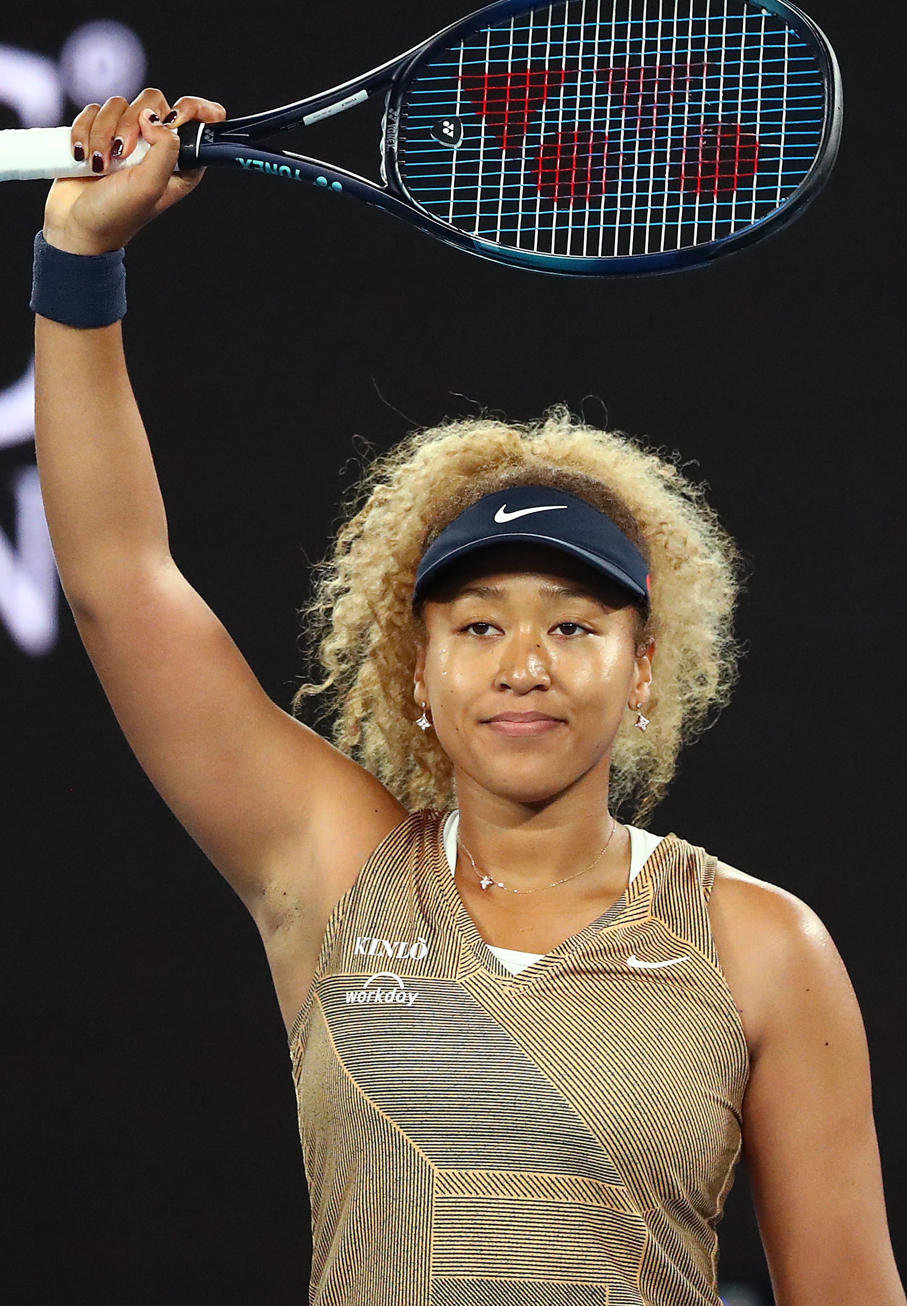 Naomi Osaka holding up a tennis racket