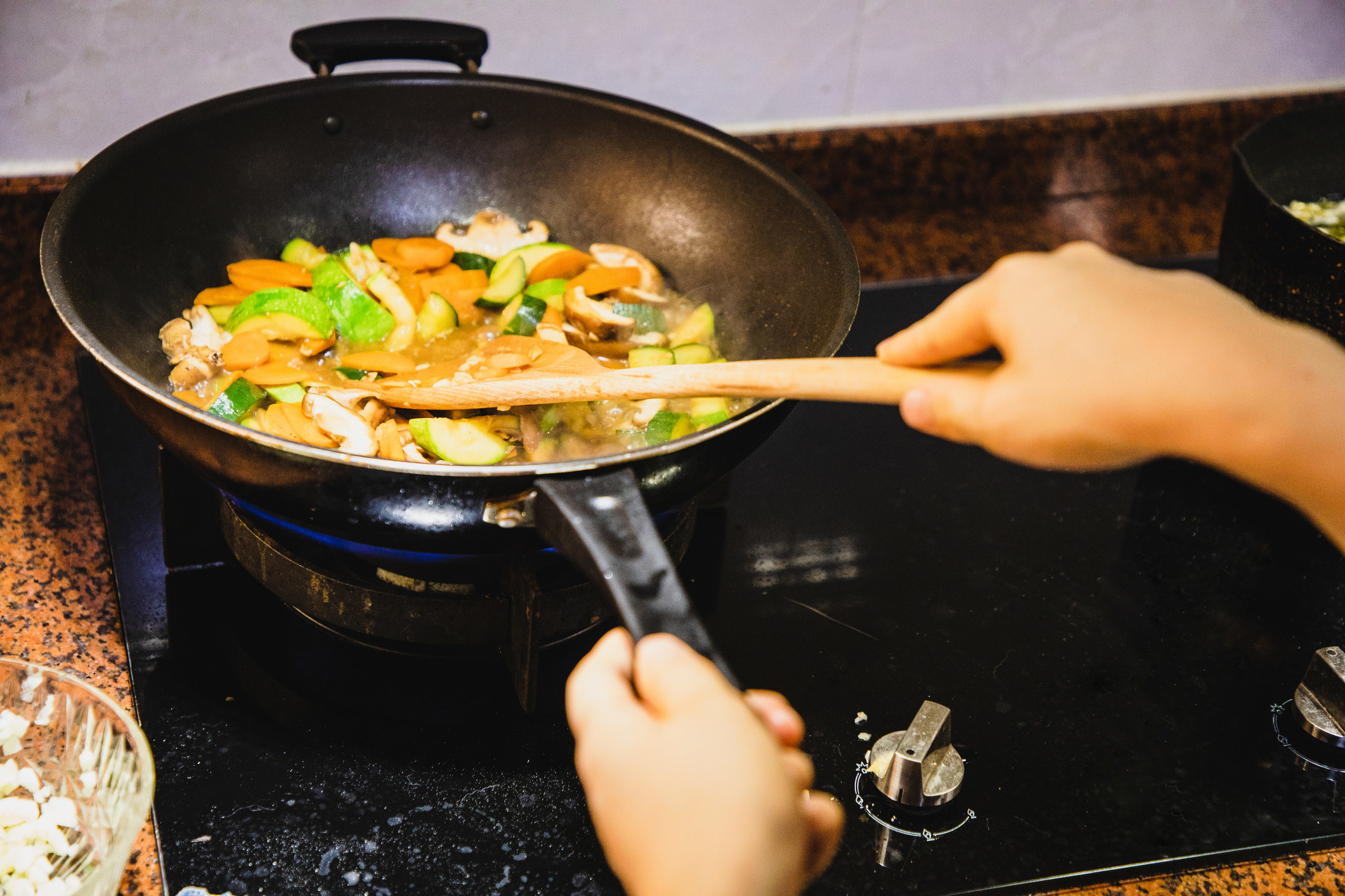A person stir-frying vegetables.