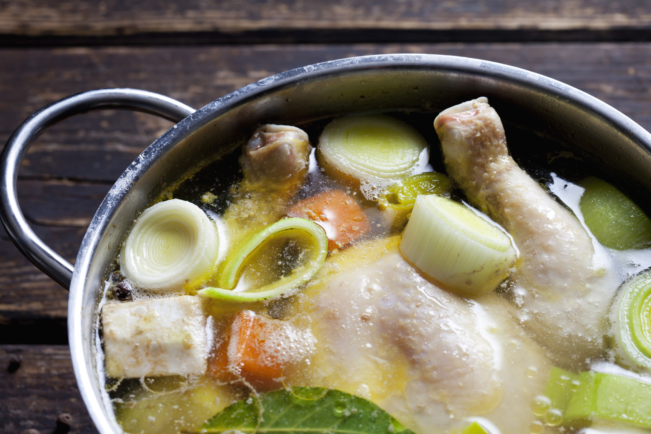 A pot of chicken soup cooking.