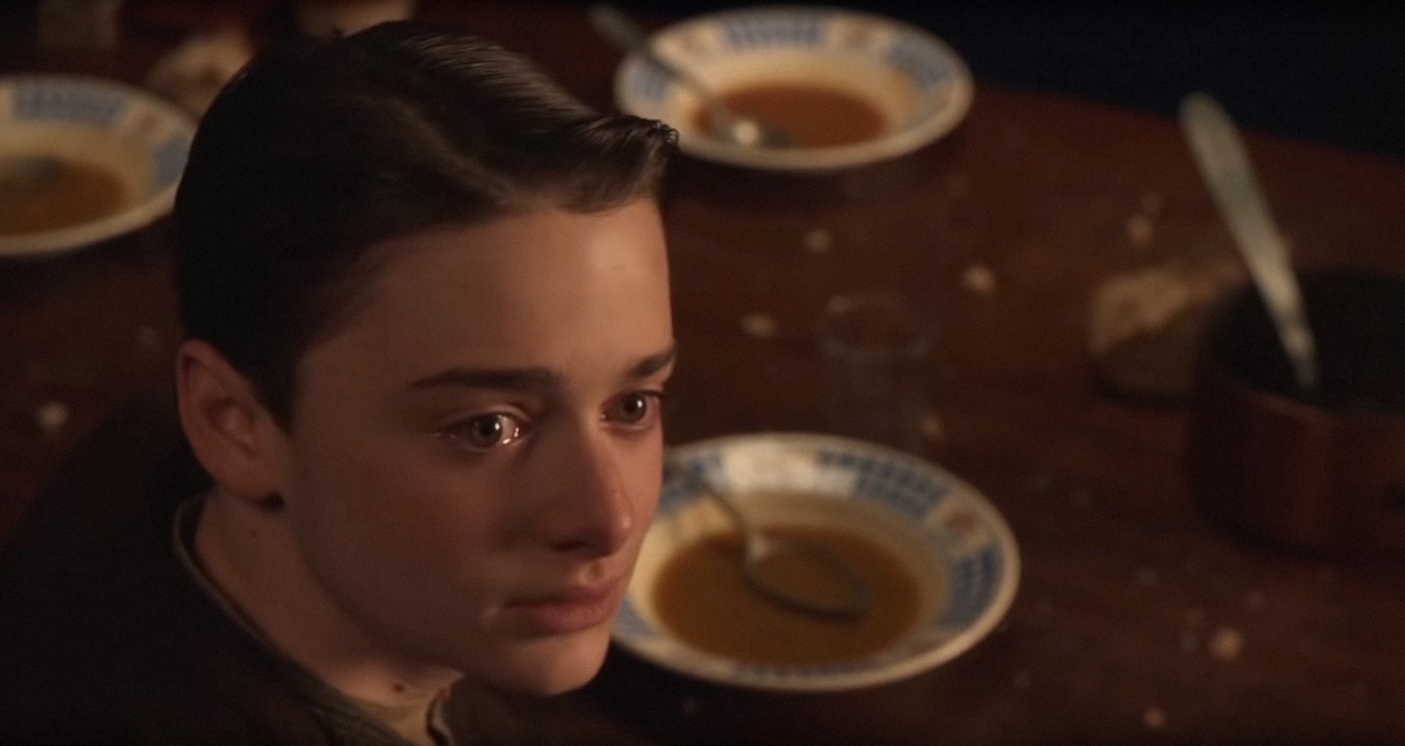 Noah looking tearful at a table in a scene from Waiting for Anya