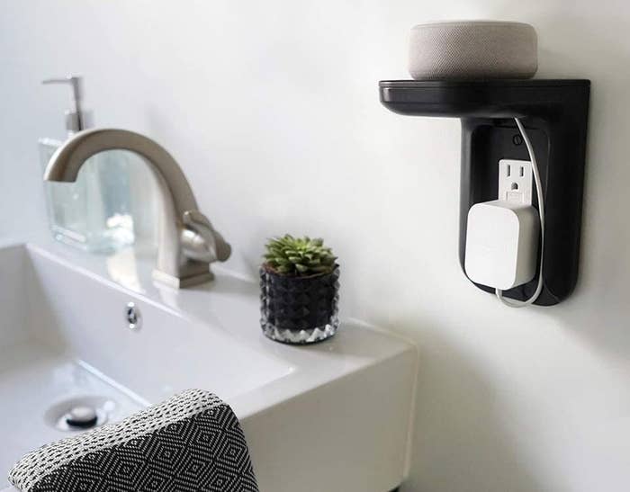 A small shelf mounted above an electrical outlet by a sink