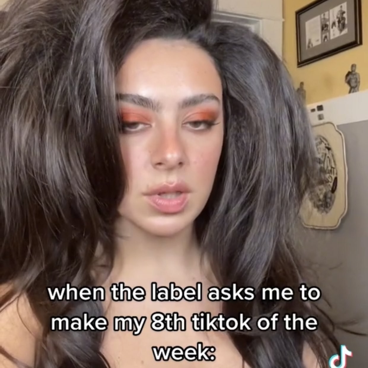 A screenshot of a depressed-looking Charli saying &quot;When the label asks me to make my eighth TikTok of the week&quot;