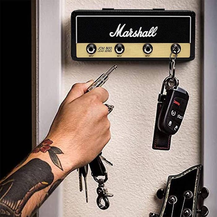 A person putting their keys on the holder