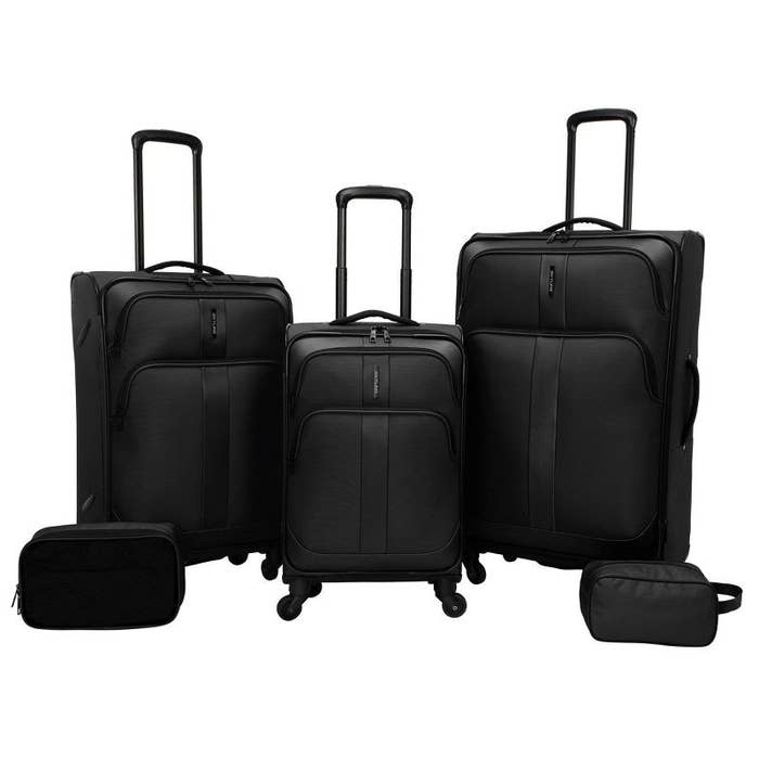 An image of a five-piece suitcase set that includes three spinner suitcases, a packing cube, and a travel kit