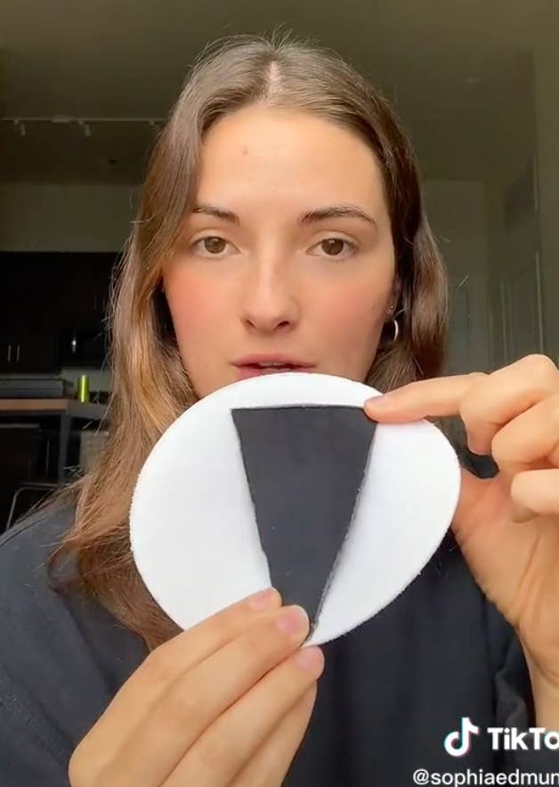 Sophia holding up a piece of fabric cut into a long upside-down triangle