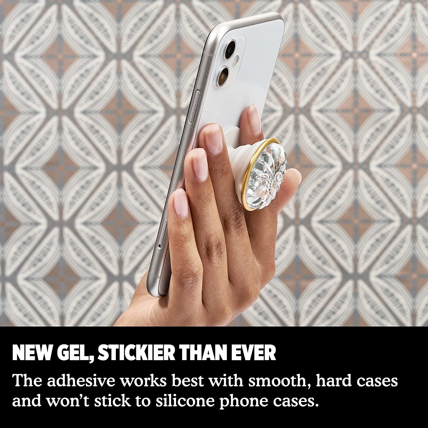 a person holding up a phone with the jewelled popsocket on the back