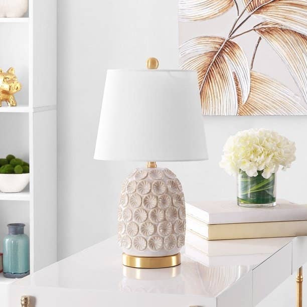 The table lamp with white shade sitting on table