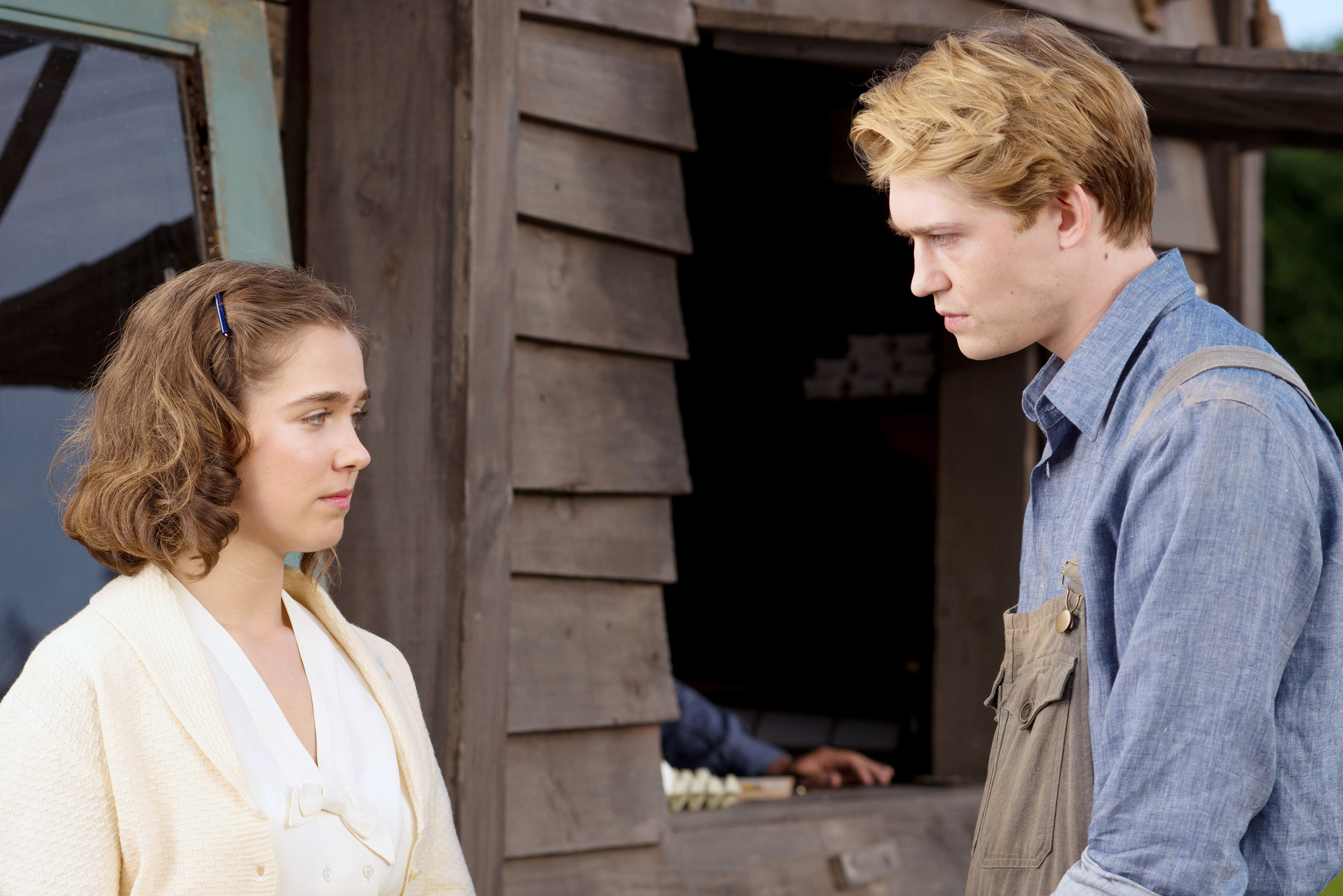 Joe Alwyn and Haley Lu Richardson stand outside, looking seriously at each other
