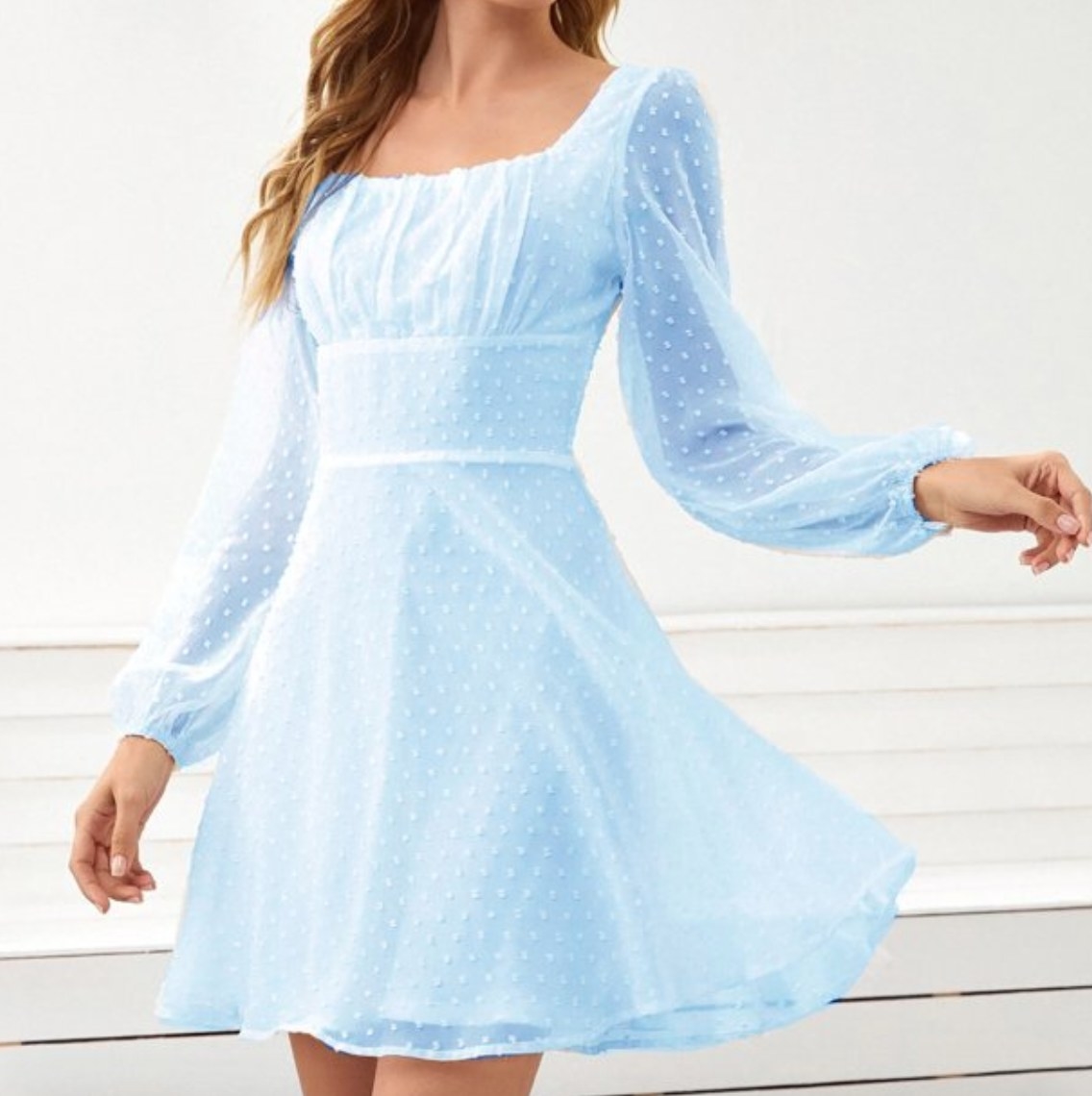 a model wearing the long sleeve mini dress in baby blue