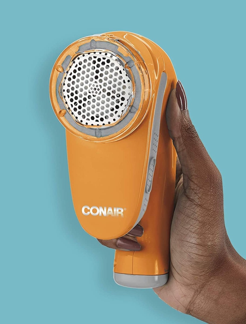A person showing the face of the fabric shaver