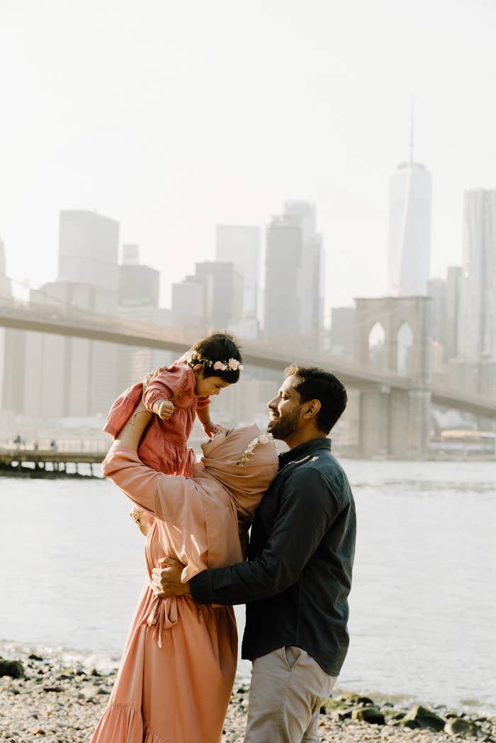 A family near a river in NYC holding their child